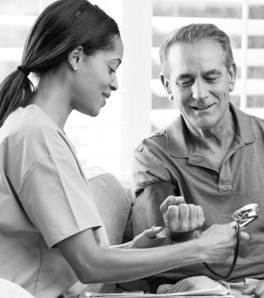 caregiver doing blood pressure measurement for elder man