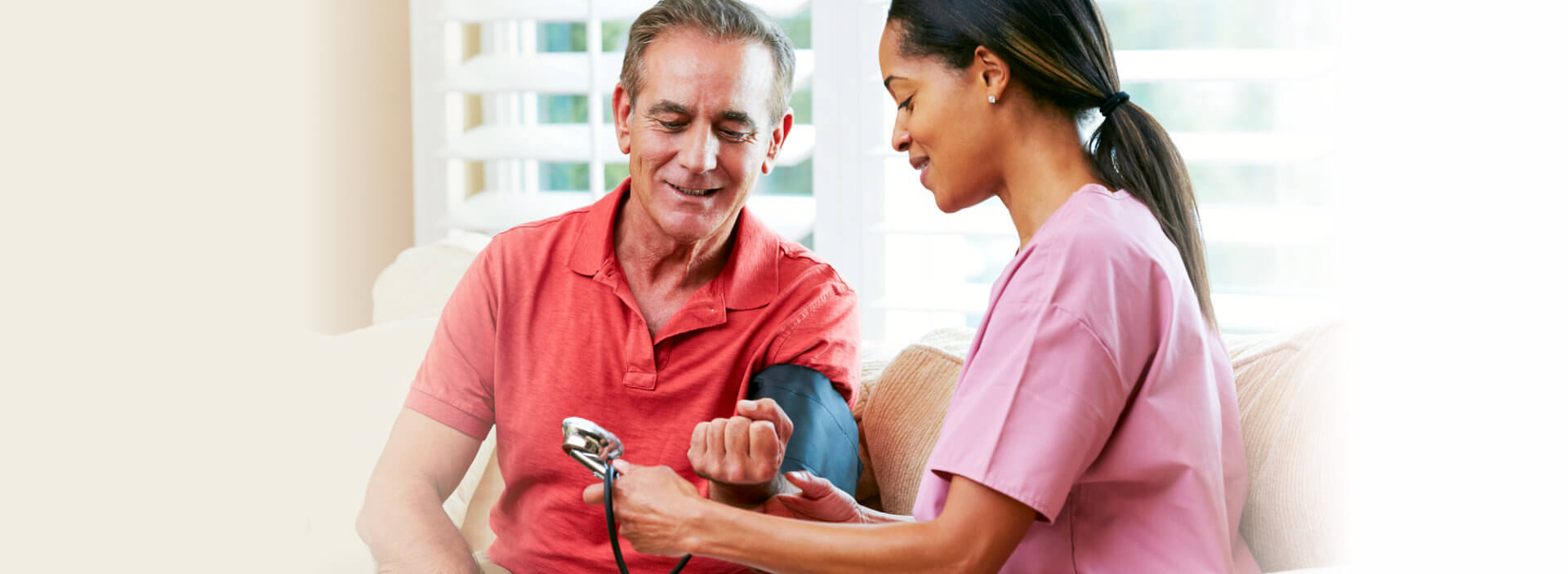 caregiver doing blood pressure measurement for elder man